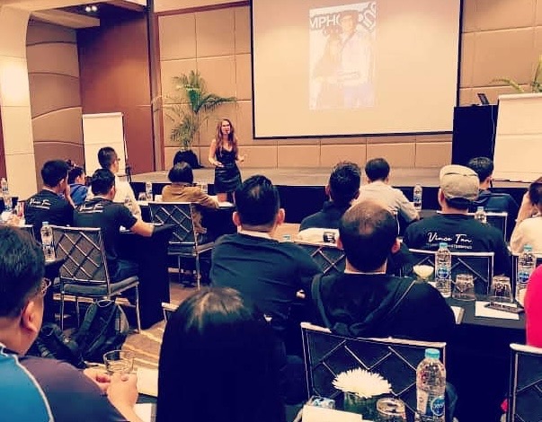 Simina speaking to a room at a conference